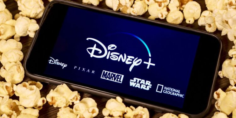 The Disney Plus logo on a phone surrounded by popcorn