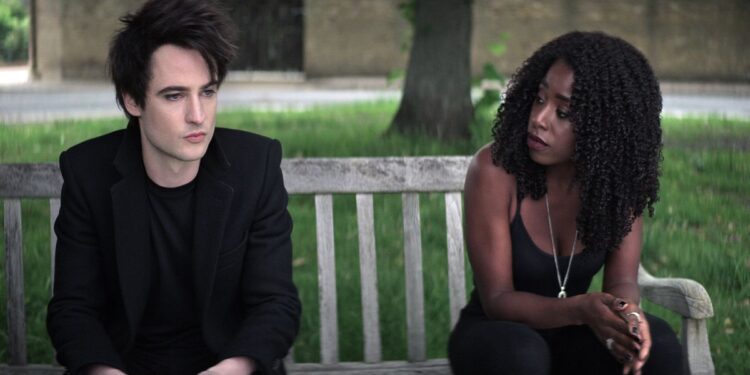 (L to R) Tom Sturridge as Dream, Kirby Howell-Baptiste as Death, on a bench, in The Sandman
