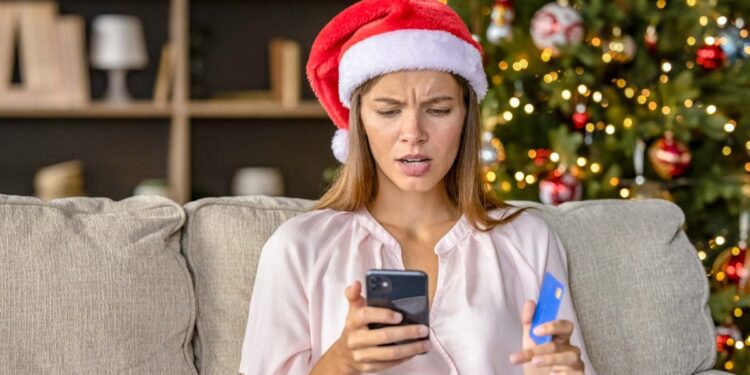 A holiday shopper looking at their smartphone in shock