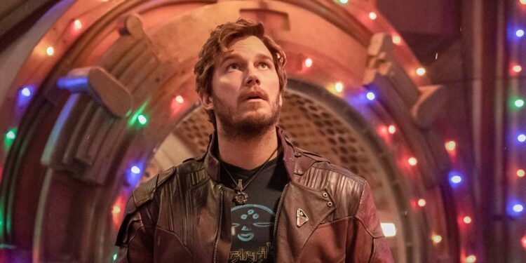 Chris Pratt as Peter Quill/Star-Lord in front of holiday lights adorning a metal entrance in The Guardians of the Galaxy Holiday Special