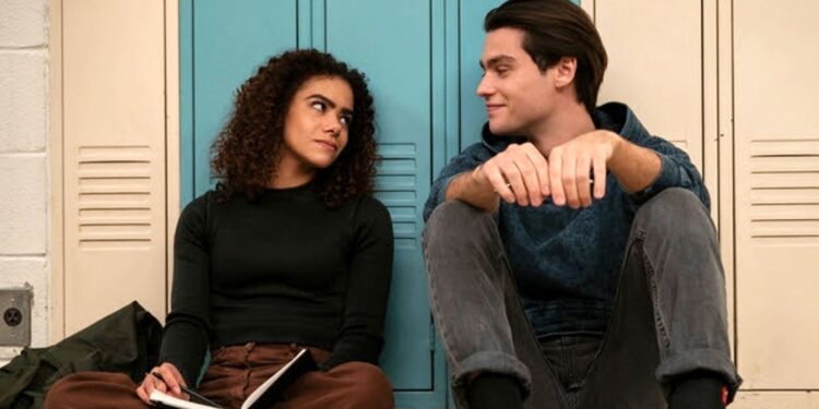 (L to R) Antonia Gentry as Ginny Miller and Felix Mallard as Marcus Baker sit against lockers in Ginny and Georgia season 2